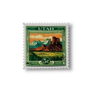May include: A green and white postage stamp with a picture of a red rock formation in a desert landscape. The stamp says "UTAH" and "5c" in the center.