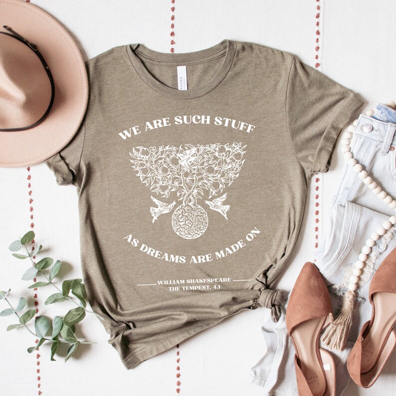 May include: A green t-shirt with a white graphic print of a tree with birds and the text "We are such stuff as dreams are made on - William Shakespeare, The Tempest, 4.1".
