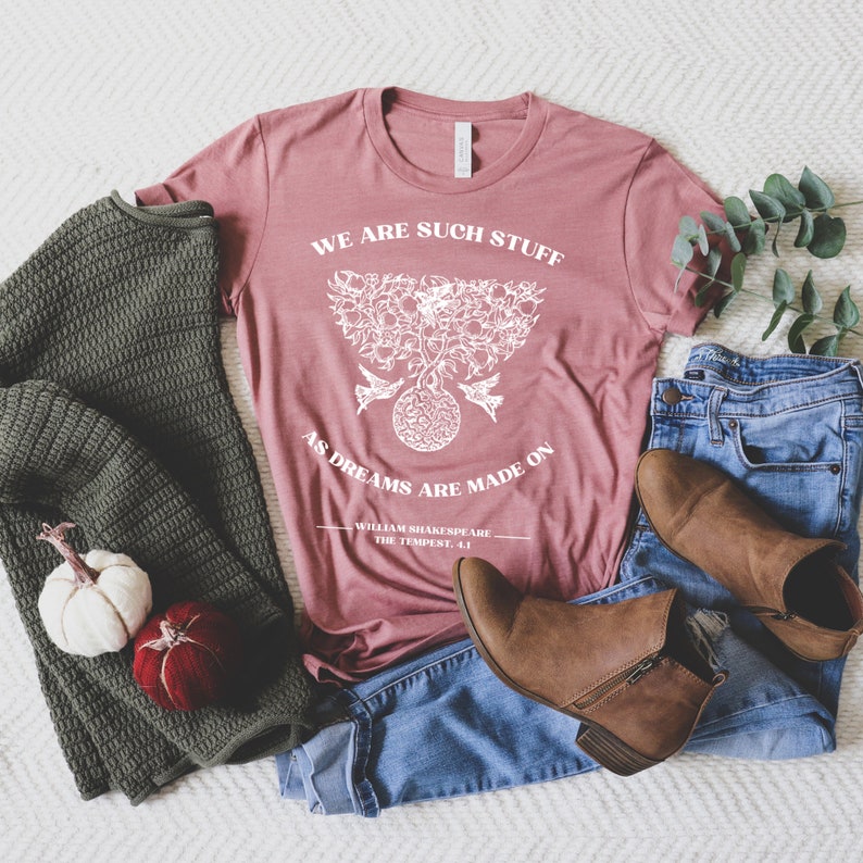 May include: A dusty rose t-shirt with a white graphic of a tree with birds and the quote "We are such stuff as dreams are made on - William Shakespeare, The Tempest, 4.1"