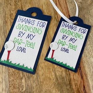 May include: Two blue and white gift tags with a golf ball and tee design. The text on the tags reads "Thanks for swinging by my par-tee! Love."