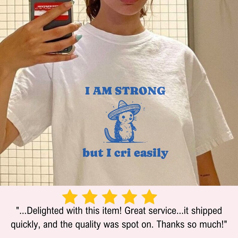 May include: White t-shirt with a blue cartoon mouse wearing a sombrero and the text "I AM STRONG but I cri easily".