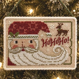 Adorno de Papá Noel 2022, adorable rostro vintage, barba ondulada y patrón de punto de cruz de arte popular primitivo de Rodolfo el reno en formato PDF de Acadia Stitchery.