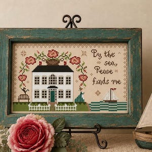 Frid hittar mig, ett stort hus, korg med blommor, flicka vid havet primitivt folkkonst korsstygnsmönster av Acadia Stitchery
