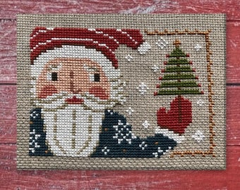 Papai Noel patriótico, com rostinho vintage fofo, traje vermelho, branco e azul, além de árvore - padrão de ponto cruz em estilo folk primitivo em PDF da Acadia Stitchery.