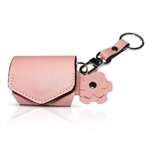May include: A pink leather keychain with a small pouch and a flower charm. The pouch has a flap that closes with a snap.