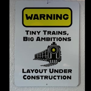 9" x 12" - Warning: Tiny Trains, Big Ambitions – Layout Under Construction Metal Sign