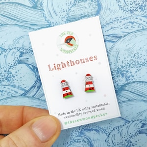 Könnte beinhalten: Ein Paar rote und weiße Leuchtturmohrringe aus Holz. Die Ohrringe befinden sich auf einer weißen Karte mit dem Text "THE ZEN WOODPECKER" und "Lighthouses". Die Karte enthält auch den Text "Hergestellt in Großbritannien aus nachhaltigem, verantwortungsvoll gewonnenem Holz" und "@thezenwoodpecker".