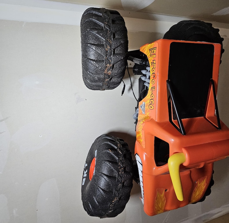 May include: Orange and black toy monster truck with large wheels and the text "El Loco" on the side.