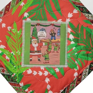 May include: Red and green quilted hot pad with a hanging loop. The hot pad features a cartoon image of Santa Claus and elves with the text "I said I'm not wrapping!"