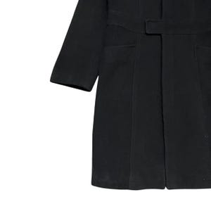 May include: A black coat with a belt and two front pockets. The coat has long sleeves and a tailored fit. The fabric appears to be a wool blend. The coat is a classic style.