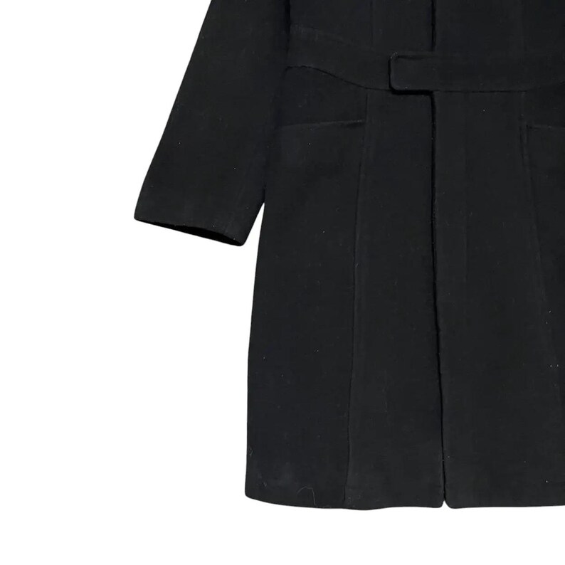 May include: A black coat with a belt and two front pockets. The coat has long sleeves and a tailored fit. The fabric appears to be a wool blend. The coat is a classic style.