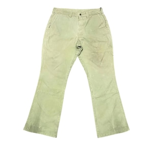 Op de afbeelding: Een lichtgroene werkbroek met een rechte pijp en een lichte flare aan de onderkant. De broek heeft een knoopsluiting en riemlussen.