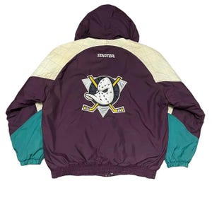 Op de afbeelding: Een witte keramische mok met een zwart handvat en de tekst "But First, Coffee" in handschriftstijl. De mok staat op een wit oppervlak. De mok is waarschijnlijk 325 ml.