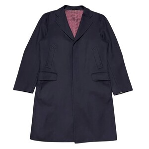 May include: A navy blue long coat with a single breasted closure and a notched collar. The coat has a plain front and two flap pockets.