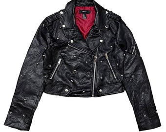 May include: Black faux leather moto jacket with silver studs and a zipper closure. The jacket has a cropped fit and long sleeves.