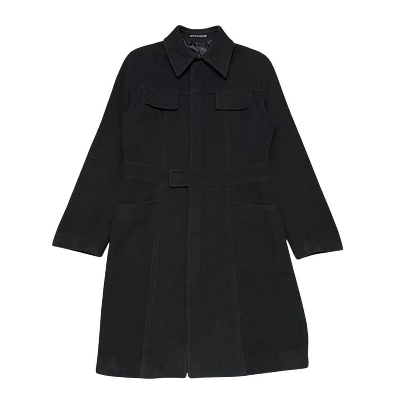May include: A black coat with a collared neckline, two chest pockets, and two lower pockets. The coat features a belt at the waist and long sleeves. The coat is made of a solid, dark material.