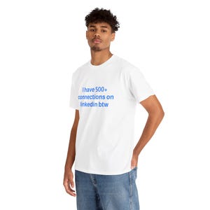 May include: White t-shirt with the blue text "I have 500+ connections on linkedin btw." The shirt is being worn by a person in blue jeans. The person is standing and has their hand in their pocket.