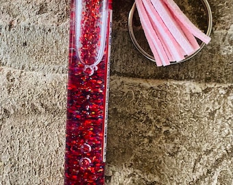 Portachiavi galleggiante con glitter rossi per prelievo di sangue. Provetta per il sangue. Fiala per il sangue. Provetta. Infermiere, tecnico di laboratorio. San Valentino. Glitter rossi. Fiala rossa.