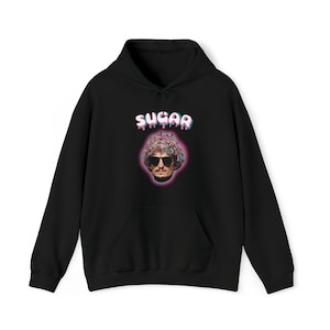 May include: Black hoodie with a graphic print of a person with sunglasses and a pink and blue "SUGAR" text.
