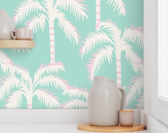 May include: A teal wallpaper with a repeating pattern of white palm trees with pink accents. The wallpaper is shown in a kitchen setting with a pitcher and a small jar on a wooden surface.