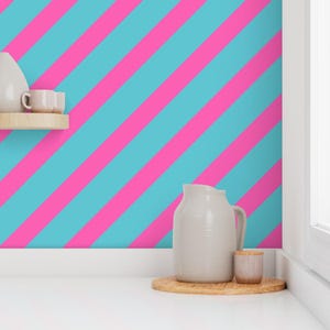 May include: A bright, colorful interior scene featuring a wall with diagonal stripes in vibrant pink and turquoise. A white pitcher, small cup, and other decorative items sit on a wooden shelf and tray, adding a touch of elegance to the space.