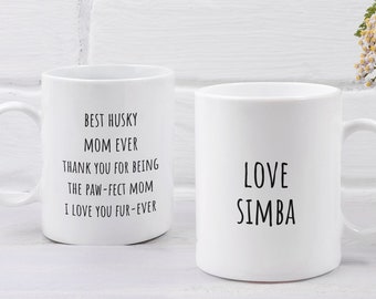 Può includere: Due tazze in ceramica bianca con testo nero. La tazza a sinistra dice "Best Husky Mom Ever, Thank You For Being The Paw-fect Mom, I Love You Fur-Ever". La tazza a destra dice "Love Simba".