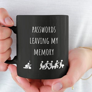 Peut inclure: Mug à café noir avec du texte blanc qui dit "PASSWORDS LEAVING MY MEMORY" et un graphique de personnages en bâtonnets qui s'enfuient d'une personne assise.