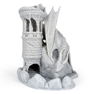 May include: A grey fantasy sculpture depicting a dragon and a tower. The dragon has detailed wings and a fierce expression, while the tower has a stone-like texture with arched openings and a small entrance.