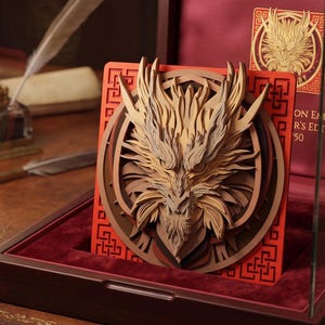 May include: A layered wooden dragon emblem plaque featuring intricate carvings in shades of tan and brown, set against a bright orange square frame with geometric patterns. The emblem is displayed inside a dark wooden box with red velvet lining.