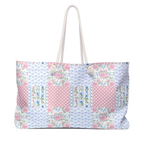 May include: A white tote bag with a patchwork design featuring pink and blue floral patterns. The bag has white rope handles.