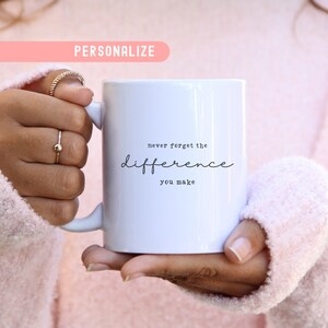 May include: White ceramic mug with black text that reads "never forget the difference you make".