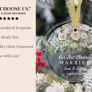 K&ouml;nnte beinhalten: Ein rundes Glasornament mit einem Blumenarrangement aus wei&szlig;en und hellrosa Rosen sowie gr&uuml;nem Blattwerk. Der Text lautet Our First Christmas MARRIED Liam & Tiffany August 22, 2026. Ein goldenes Band ist oben am Ornament befestigt.