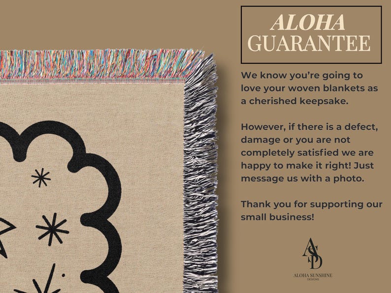 May include: Woven blanket with a beige background and a black floral design. The blanket has a fringed edge with multiple colors. The text "ALOHA GUARANTEE" is in the upper right corner.