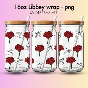 Puede incluir: Tres vasos transparentes tipo Libbey con tapas de madera, cada uno adornado con un patrón de flores rojas y lazos blancos. Cada vaso tiene una pajita blanca. El texto "16oz Libbey wrap - png" está en la parte superior.