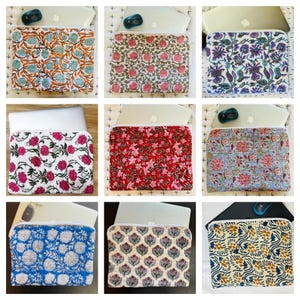 Peut inclure: Plusieurs housses pour ordinateur portable avec des motifs floraux de différentes couleurs. Les motifs incluent le turquoise et l'orange, le rose et le vert, le violet et le blanc, le rouge et le rose, et le bleu et le blanc. Chaque housse est rectangulaire avec une fermeture éclair.