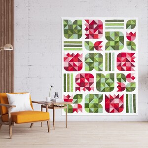 Könnte beinhalten: Eine Quiltdecke mit einem geometrischen Muster aus roten und grünen Tulpen. Die Decke besteht aus Quadraten und Dreiecken, die Farben sind hell und fröhlich.