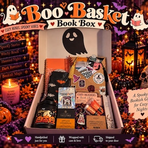 May include: A Boo Basket Book Box containing an orange notebook, a black bat-patterned fabric item, a Taylors Apple & Cinnamon tea box, a candle, a keychain, a soap bar, and stickers. The box features a ghost icon and text reading Boo Basket.