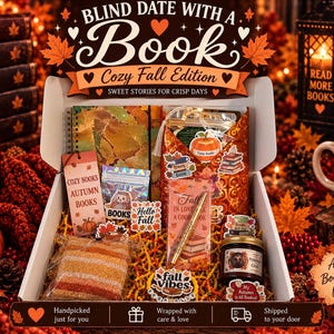 May include: A white gift box labeled Blind Date with a Book Cozy Fall Edition containing a notebook, a gold pen, a jar of pumpkin chai candle, a small bag of treats, and various autumn-themed stickers, all nestled on yellow shredded paper filler.