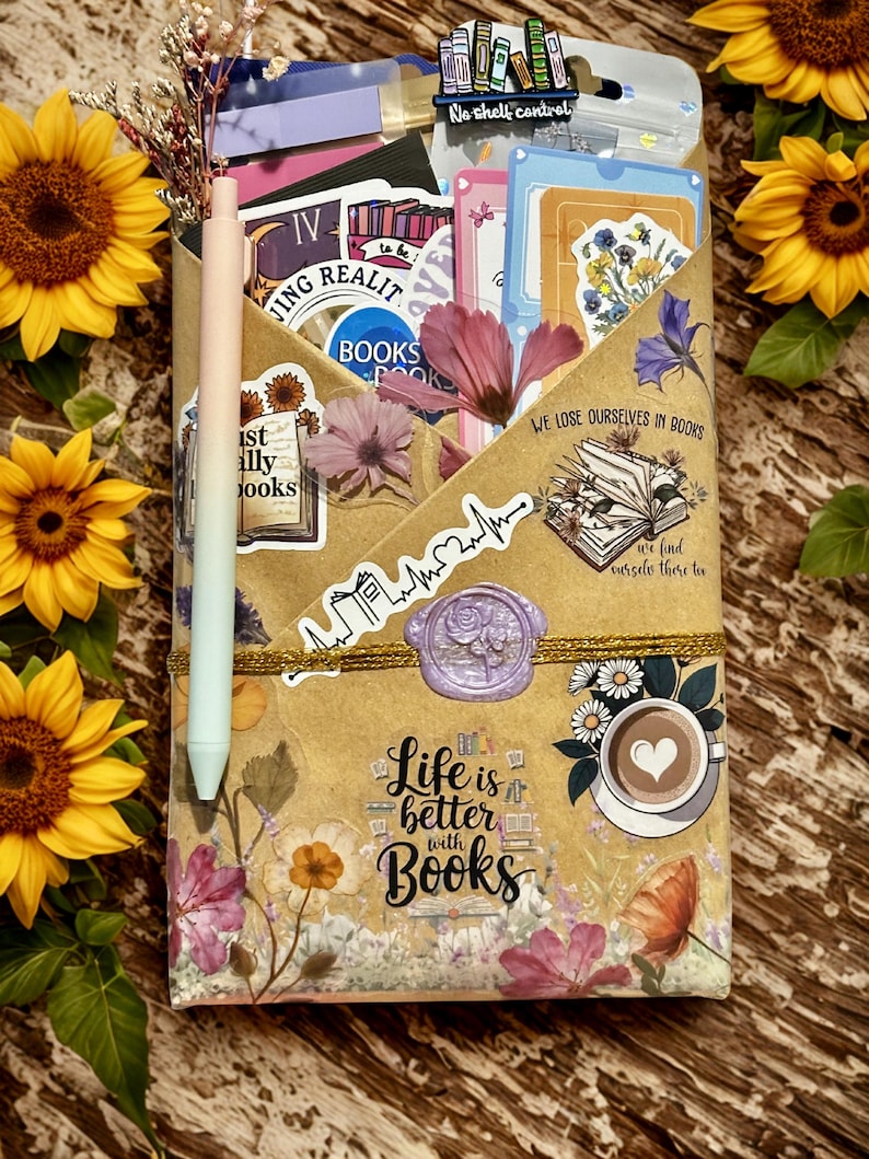 Pu&ograve; includere: Una busta di carta marrone riempita con adesivi, cartoline e una spilla con la scritta No shelf control. Una penna color pastello &egrave; fissata sul lato. La busta presenta illustrazioni floreali, un sigillo in ceralacca e il testo Life is better with Books.