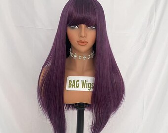 May include: A long, straight, purple wig with bangs. The wig is on a mannequin head and has a label that says "BAG Wigs".
