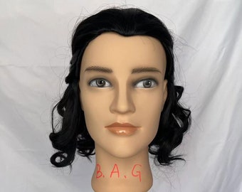 May include: A mannequin head with long, black, curly hair. The mannequin is wearing a wig. The mannequin's neck has the letters "B.A.G" written on it.