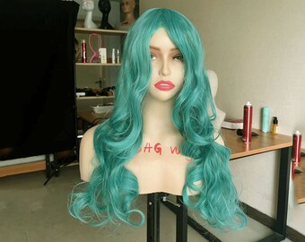 May include: A long, teal blue wig with loose curls. The wig is styled on a mannequin head.