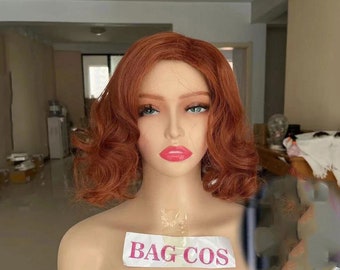 May include: A mannequin head with a short, curly, auburn-colored wig. The wig is styled in a vintage, pin-up style. The mannequin is wearing a white label that says "BAG COS".