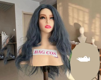 May include: A mannequin head with a blue-grey wig. The wig has long, wavy hair. The mannequin has a fair complexion, red lipstick, and the text "BAG COS" on a label.