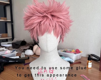 May include: Pink and black wig styled in a spiky, messy look. The wig is on a mannequin head and the text "You need to use some glue to get this appearance" is written on the mannequin's chest.