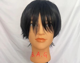 May include: A black wig with short, straight bangs on a mannequin head. The mannequin head has a neutral expression and is labelled "B.A.G."