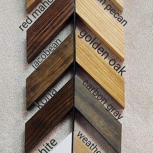 May include: A wood stain color chart with 10 different wood stain colors. The colors are labeled from top to bottom: natural, early american, red mahogany, Jacobean, kona, carbon gray, weathered oak, white, and black.