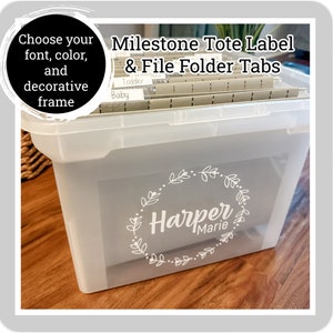 May include: White plastic storage tote with a white label that says "Harper Marie" in a wreath design. The tote has file folders with labels that say "Baby" and "Toddler".