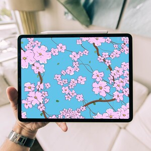 May include: A tablet computer displaying a digital illustration of pink cherry blossoms on a blue background.