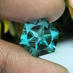 Peut inclure: Une pierre précieuse en forme d'étoile de couleur vert turquoise avec une taille facetée. La pierre précieuse est taillée en forme hexagonale avec une étoile au centre.